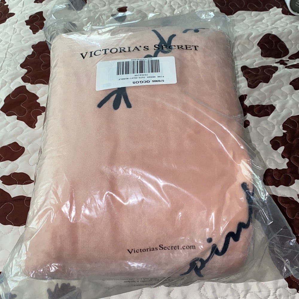 NWT PINK blanket from Victoria’s Secret. Pink in color with black writing.